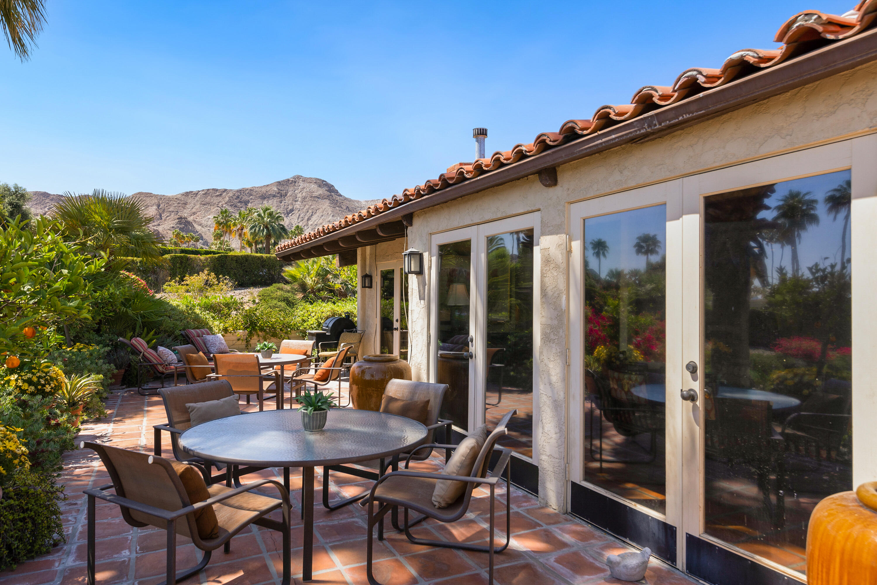 40162 Vía Del Oro Rancho Mirage, CA 92270 - Photo 27 of 34 a view of a patio with table and chairs and potted plants