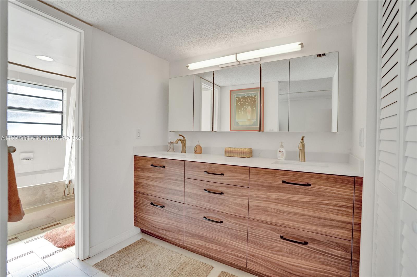 337 Ives Dairy Road, Unit 33704 Miami, FL 33179 - Photo 11 of 22 a bathroom with a double vanity sink and mirror