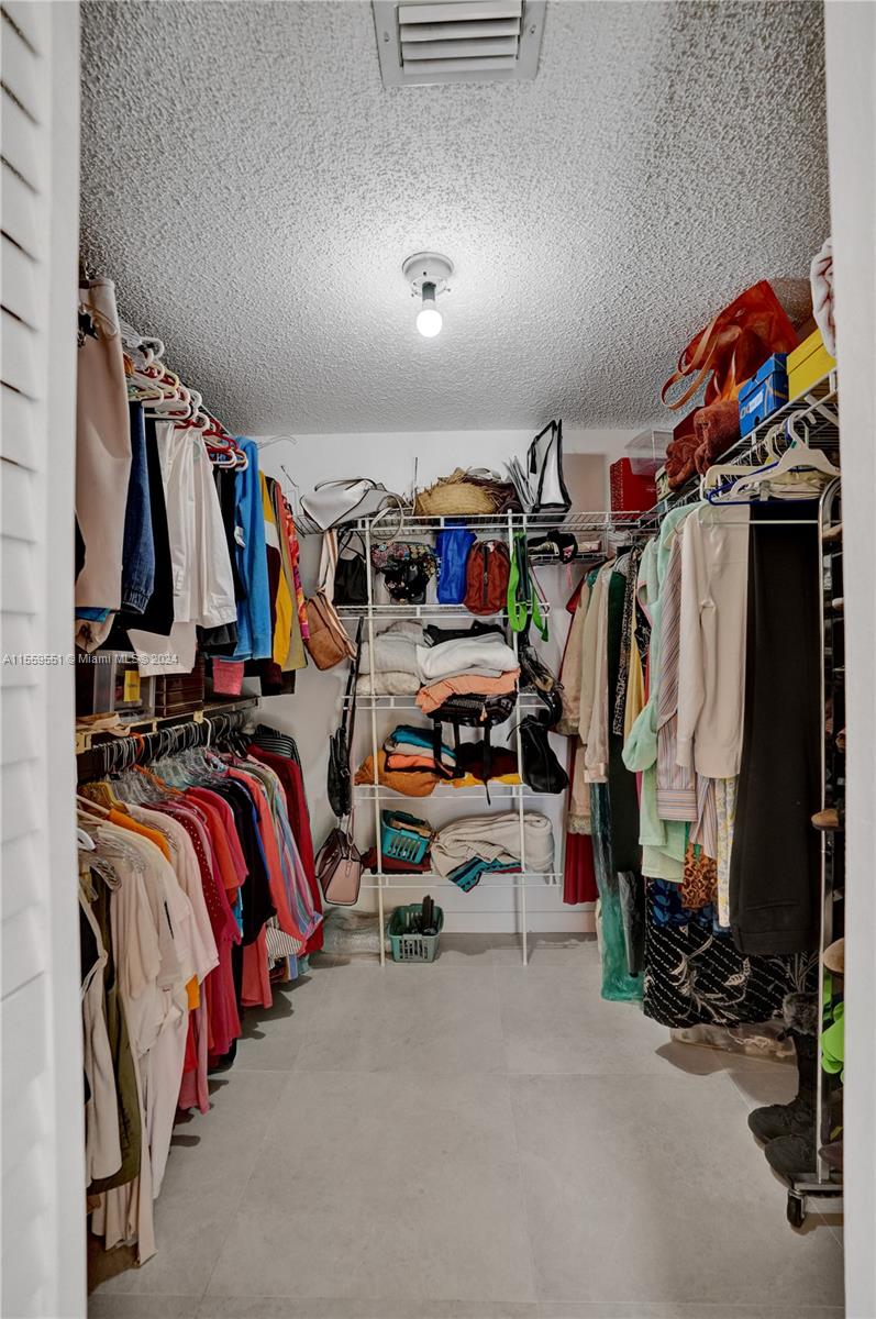 337 Ives Dairy Road, Unit 33704 Miami, FL 33179 - Photo 13 of 22 a view of walk in closet with clothes and shoes