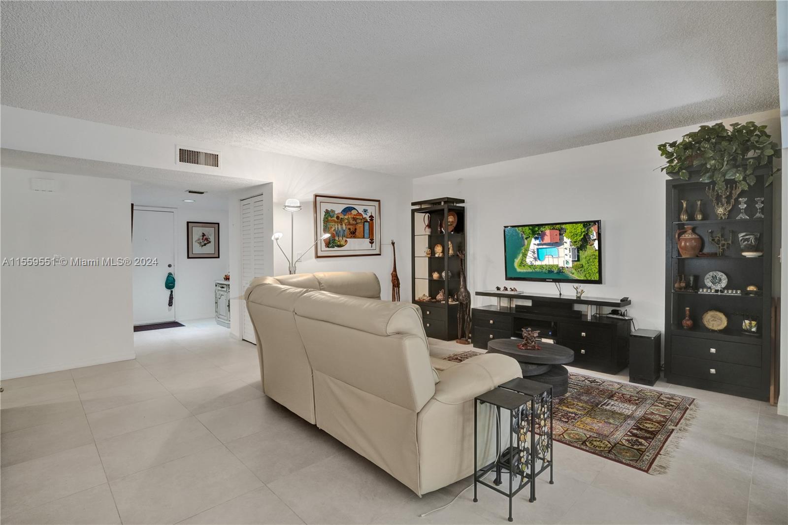 337 Ives Dairy Road, Unit 33704 Miami, FL 33179 - Photo 6 of 22 a living room with furniture and a flat screen tv