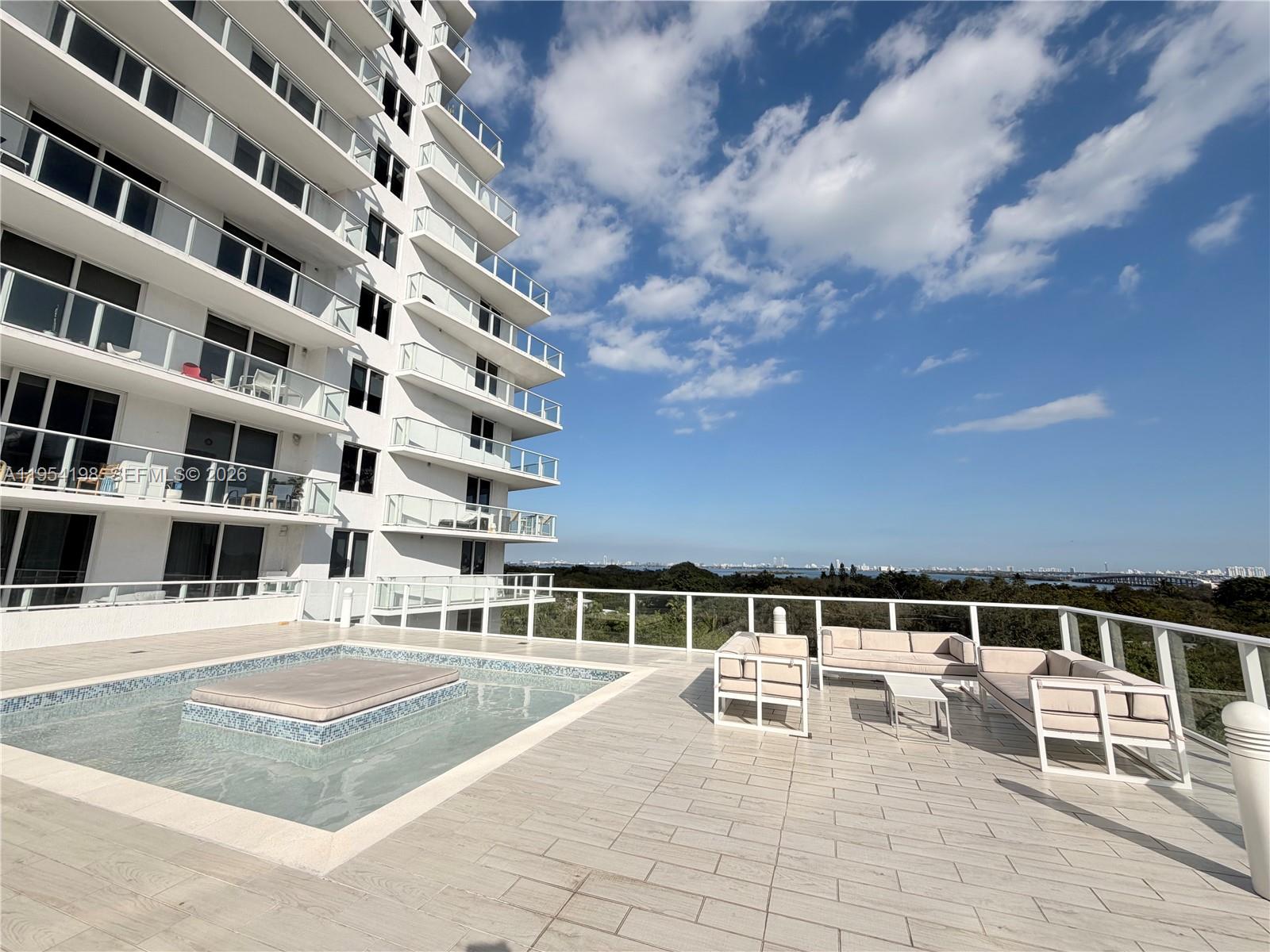 4250 Biscayne Boulevard, Unit 1014 Miami, FL 33137 - Photo 28 of 63 a view of a swimming pool with a lounge chairs