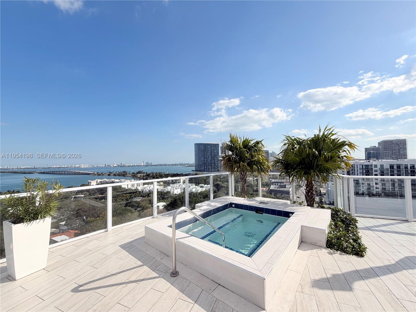 4250 Biscayne Boulevard, Unit 1014 Miami, FL 33137 - Photo 39 of 63 a view of a swimming pool with an outdoor seating and a floor to ceiling window