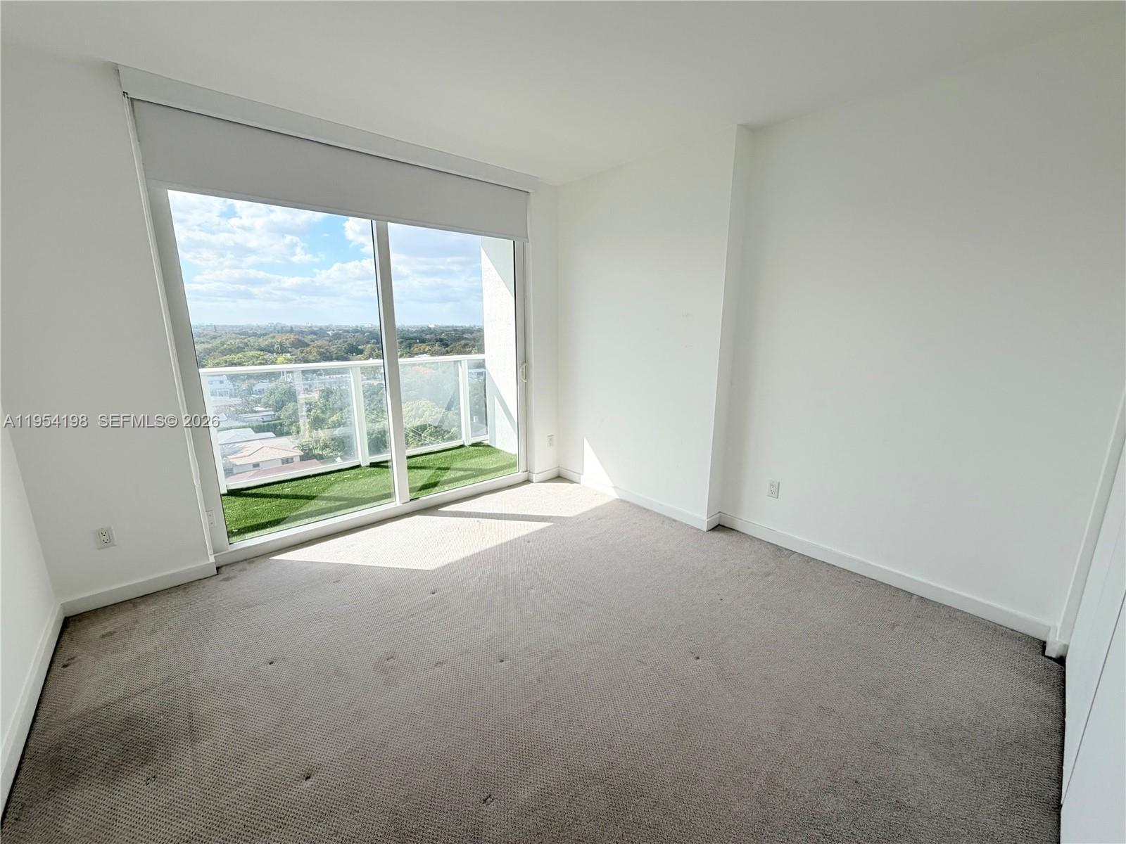 4250 Biscayne Boulevard, Unit 1014 Miami, FL 33137 - Photo 8 of 63 an empty room with an outdoor view and sliding door
