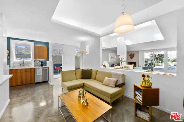 a large white kitchen with a large window and refrigerator