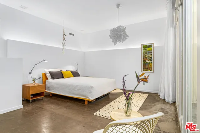 a bedroom with furniture and a large window