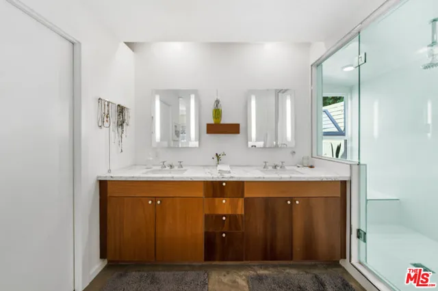a spacious bathroom with a double vanity sink a mirror and a bathtub