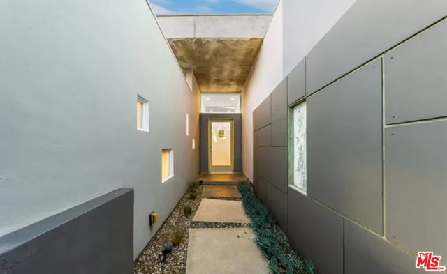 a hallway with wooden floor and cabinets