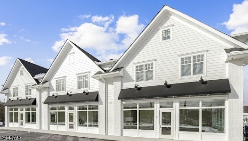 a front view of a house with a black and white roof
