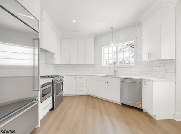 a kitchen with granite countertop white cabinets and white appliances