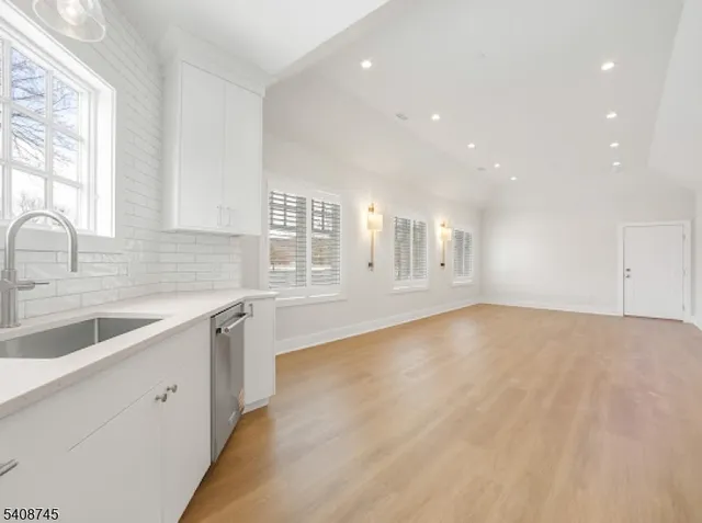 a view of a kitchen with granite countertop white cabinets and wooden floor