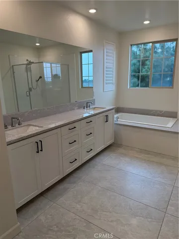 a bathroom with a granite countertop sink mirror and a bathtub