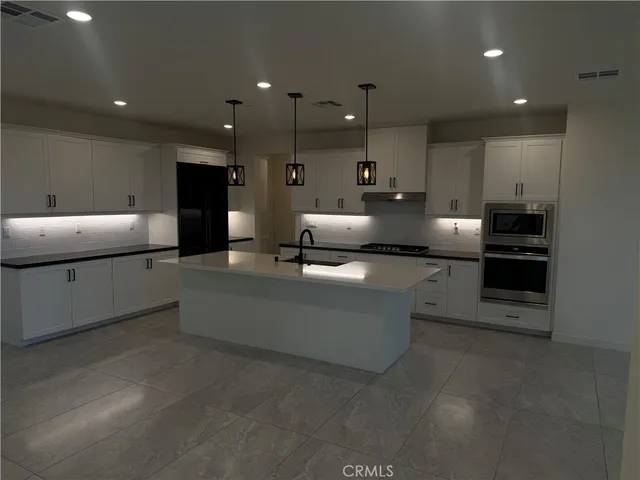 a large living room with stainless steel appliances kitchen island