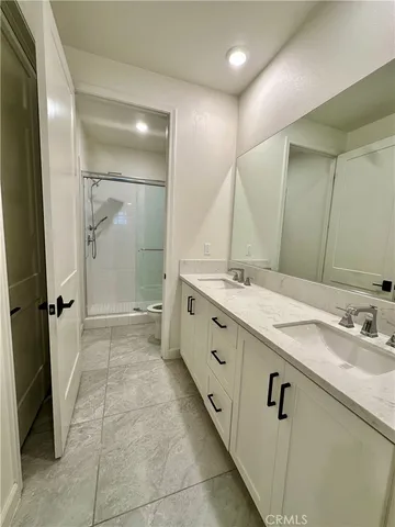 a spacious bathroom with a double vanity sink mirror and shower