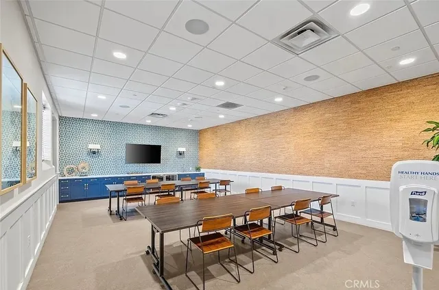 a room with furniture pool table flat screen tv and windows