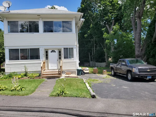 a view of a house with a small yard and sitting area