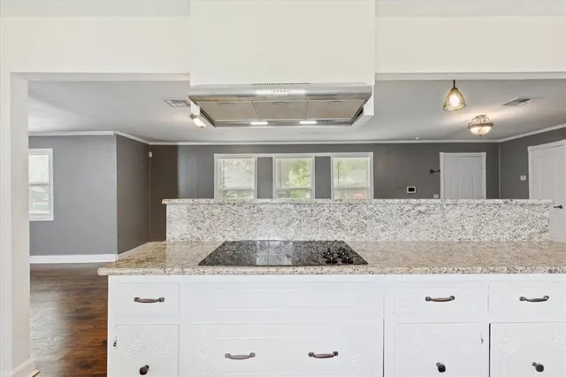 a kitchen with kitchen island granite countertop a stove and a sink