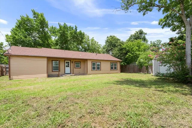 a view of a yard in front of a house with large trees
