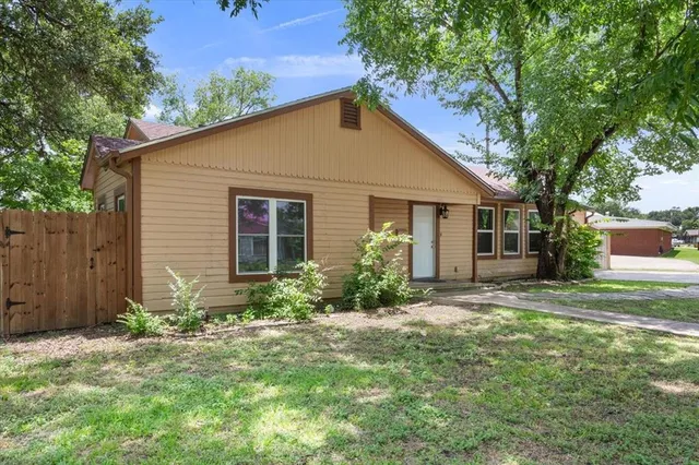 a front view of house with yard and trees around
