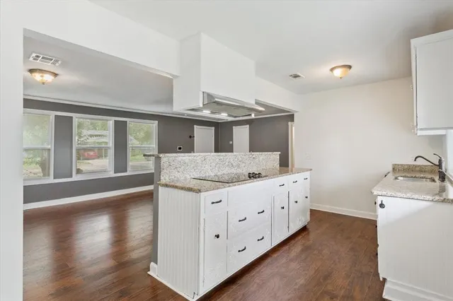 a kitchen with granite countertop a sink and a stove top oven
