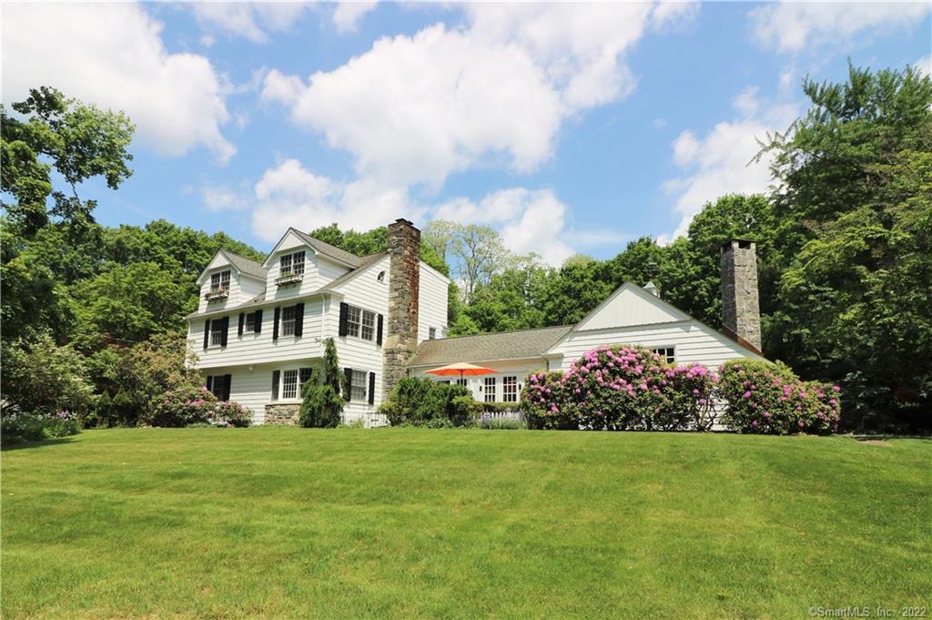 a view of a house with a big yard and large trees