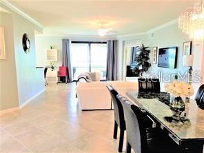 5844 Wake Forest Run, Unit 101 Lakewood Ranch, FL 34211 - Photo 6 of 16 a living room with furniture a flat screen tv and a table