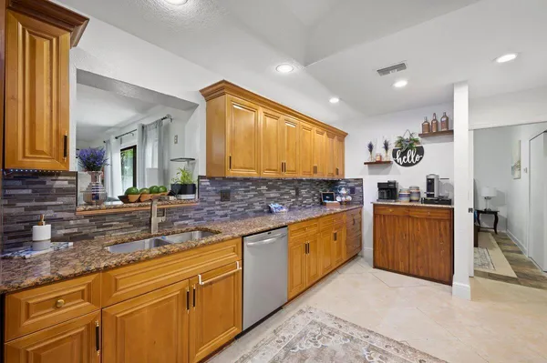 a kitchen with stainless steel appliances granite countertop a sink stove and cabinets