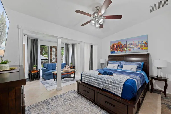 a bedroom with a large bed a chandelier and dresser