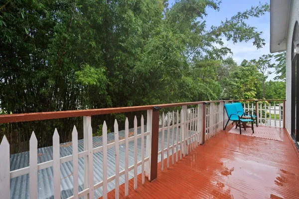 a balcony with wooden floor and outdoor seating