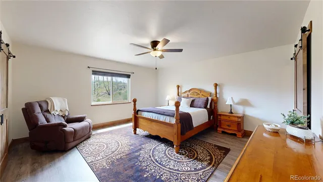a bedroom with a bed a couch and potted plant with the dresser