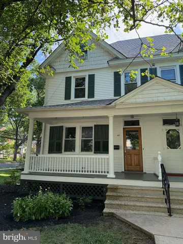 a view of a house with a small yard plants and large tree