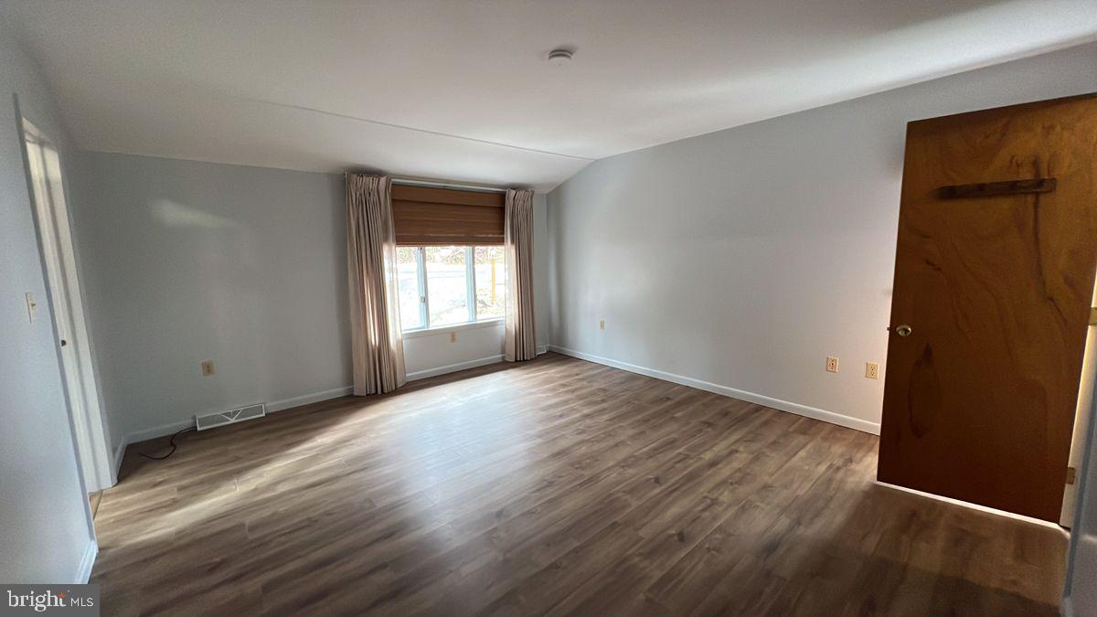 6728 Hemlock Point Road New Market, MD 21774 - Photo 14 of 28 an empty room with wooden floor and windows