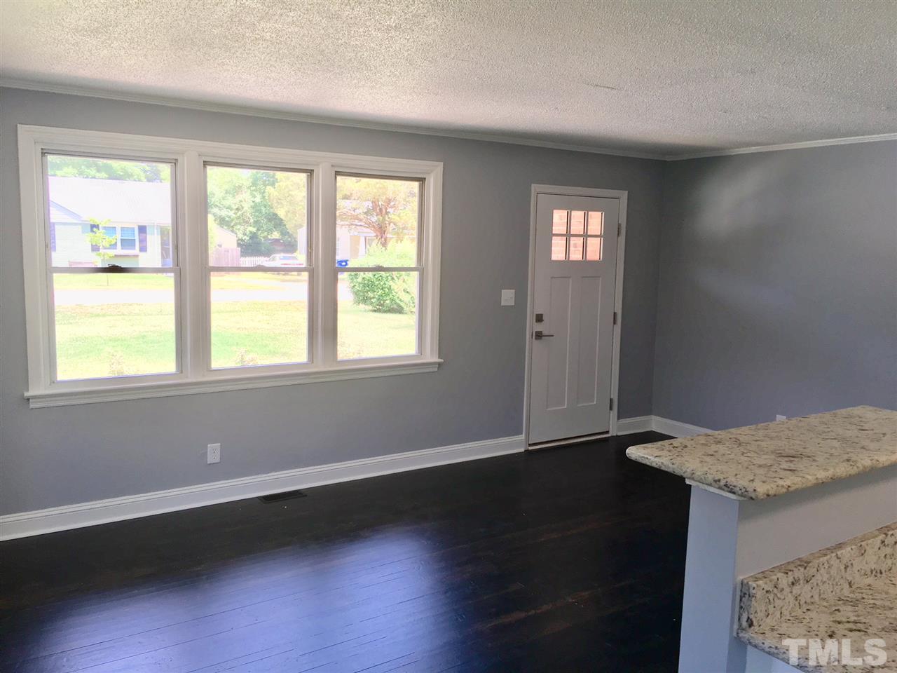 612 Brighton Road Raleigh, NC 27610 - Photo 3 of 16 a view of an empty room with wooden floor and a window