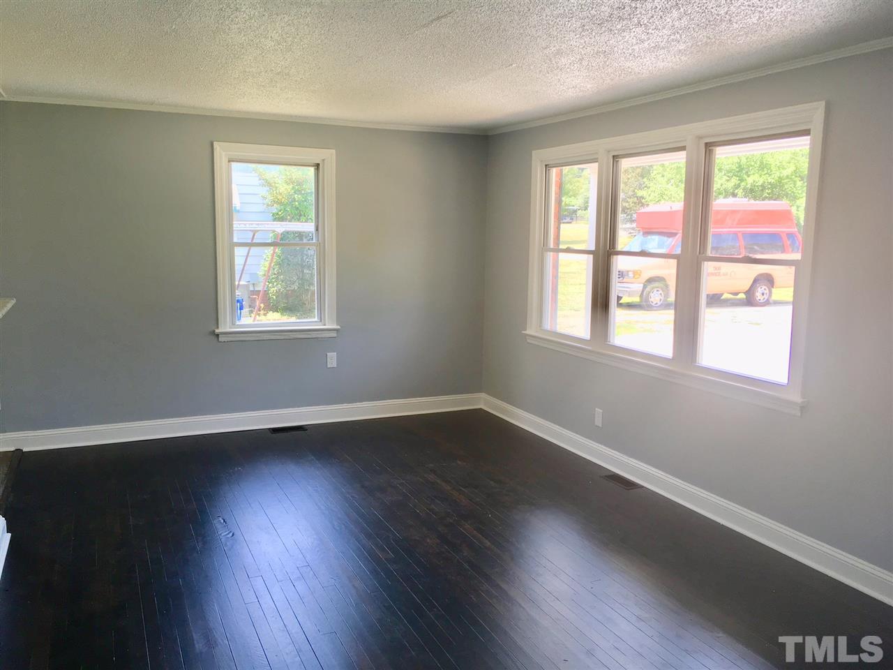 612 Brighton Road Raleigh, NC 27610 - Photo 5 of 16 an empty room with wooden floor and windows