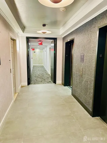 a view of a hallway with wooden floor and cabinet