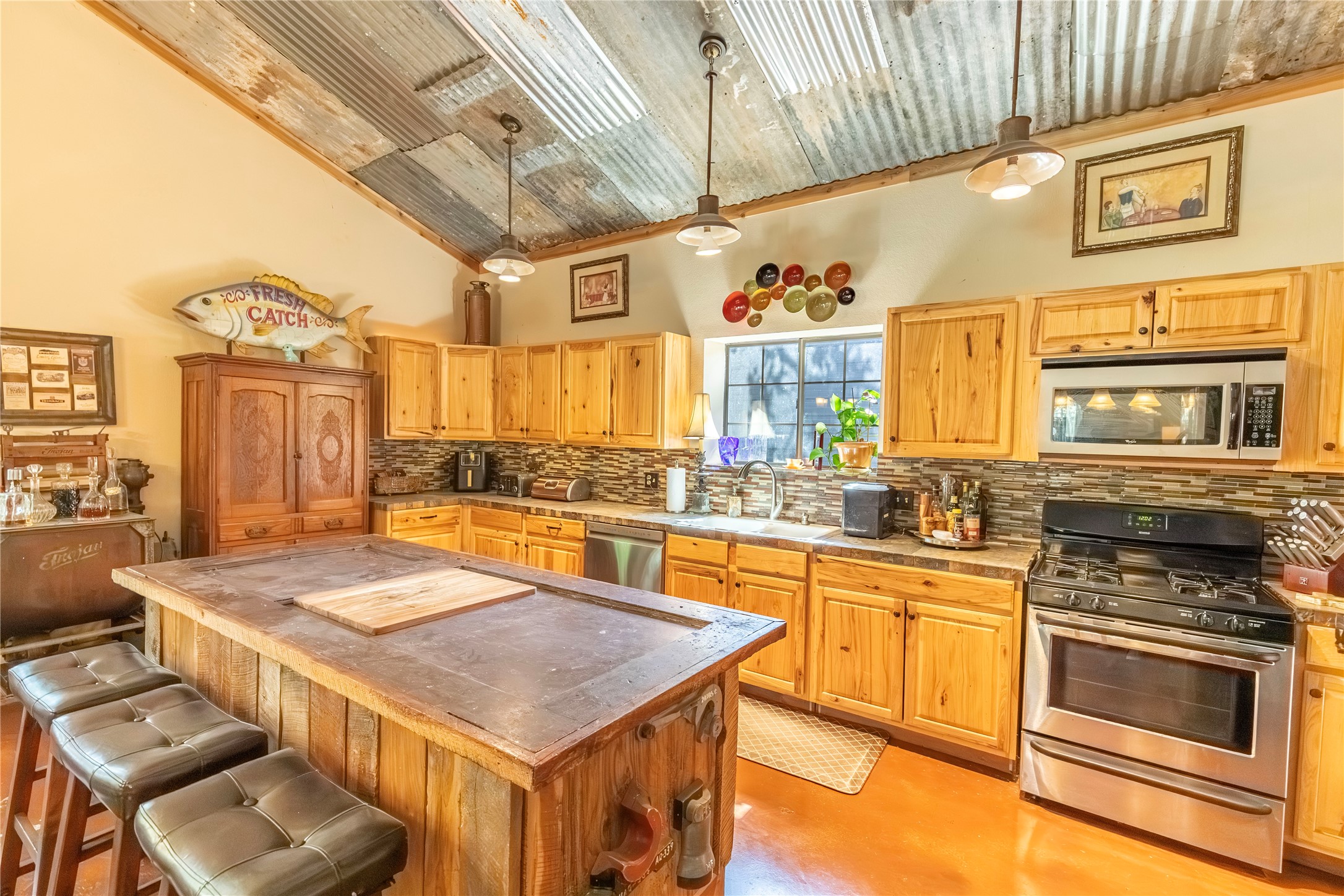 7710 Highway 36 Bellville, TX 77418 - Photo 4 of 25 The kitchen features a custom island and a gas stove, with plenty of space for cooking and gathering.