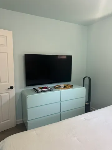 a living room with a flat screen tv and a lamp