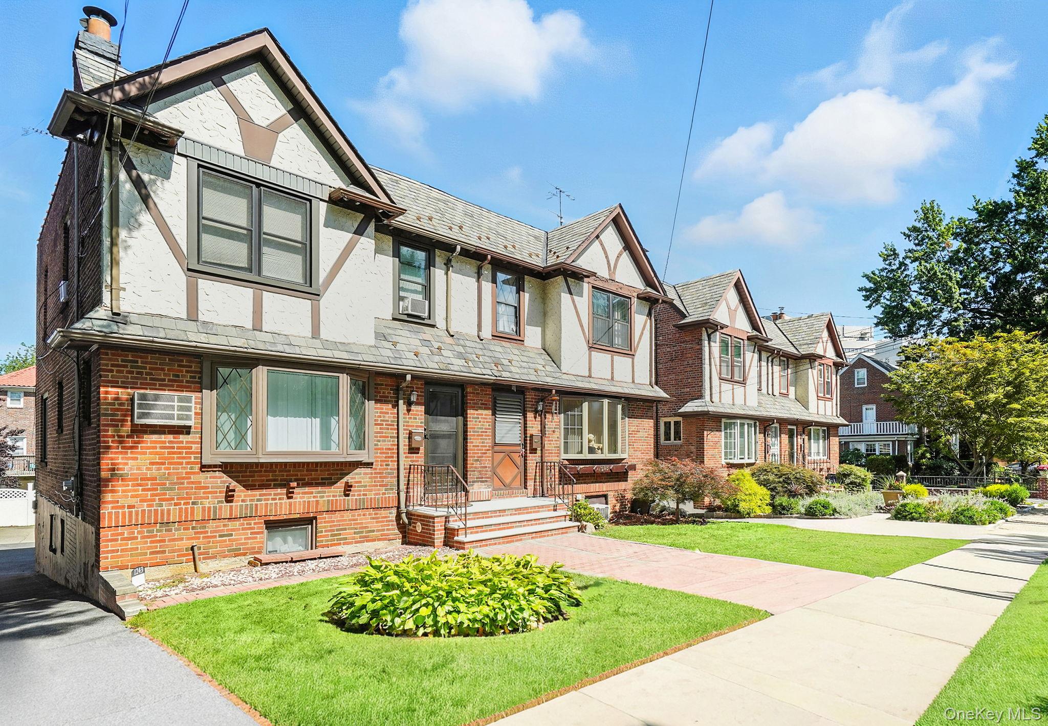 1245 Rhinelander Avenue Bronx, NY 10461 - Photo 29 of 34 English style home featuring a chimney, a high end roof, brick siding, a front yard, and stucco siding