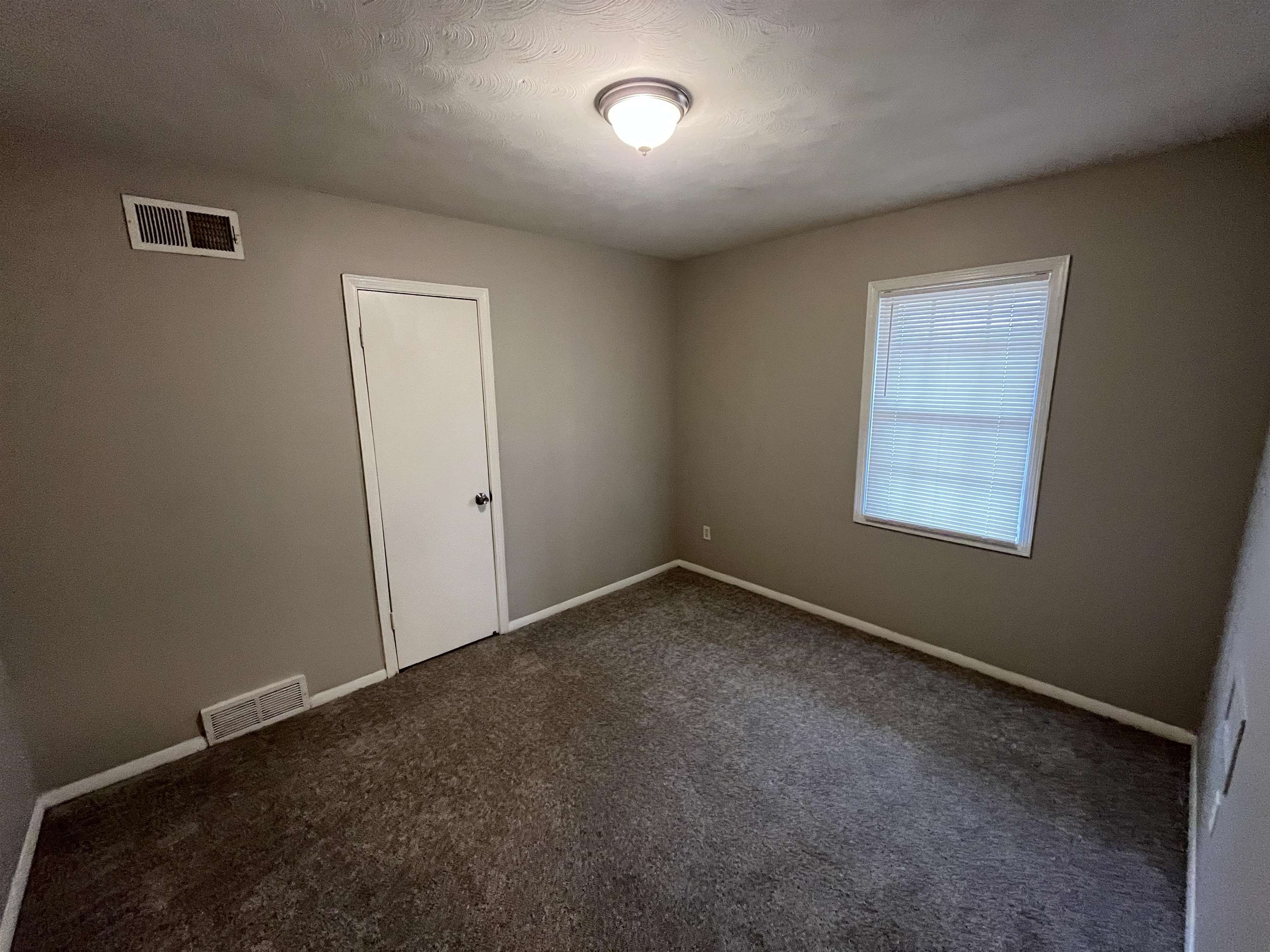 3062 Claudette Road Memphis, TN 38118 - Photo 8 of 13 Unfurnished room with dark colored carpet, visible vents, and baseboards
