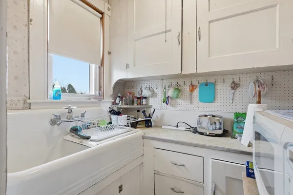 a kitchen with stainless steel appliances a sink a window and white cabinets