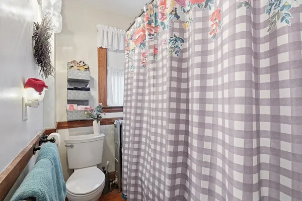 a white toilet sitting next to a shower curtain