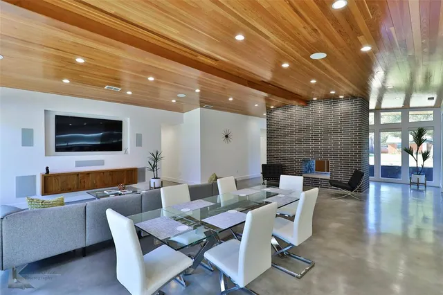 a dining room with furniture a rug and a flat screen tv