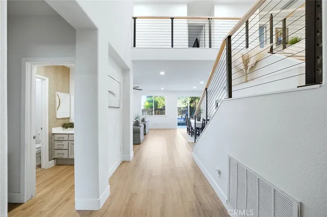 a view of a hallway with wooden floor and furniture