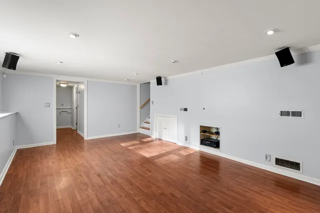 a view of empty room with wooden floor