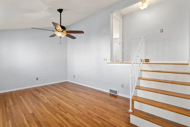 a view of a room with wooden floor and white walls