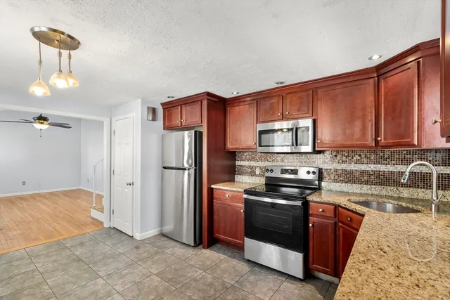 a kitchen with stainless steel appliances granite countertop a stove a sink dishwasher and a refrigerator