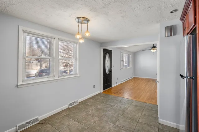 a view of empty room with window and wooden floor