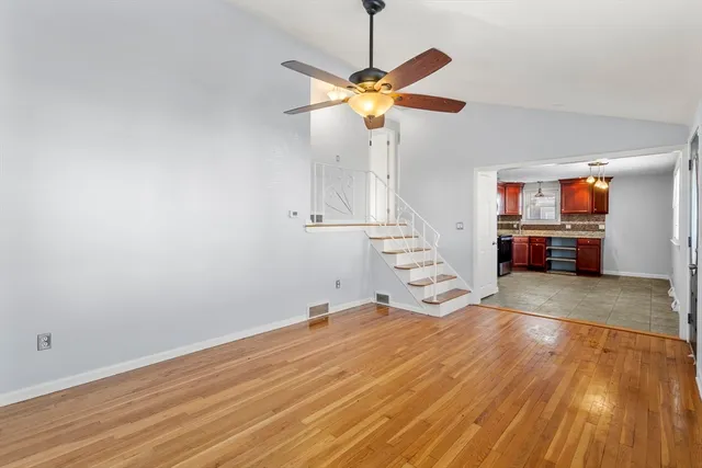 a view of a livingroom with wooden floor and a ceiling fan