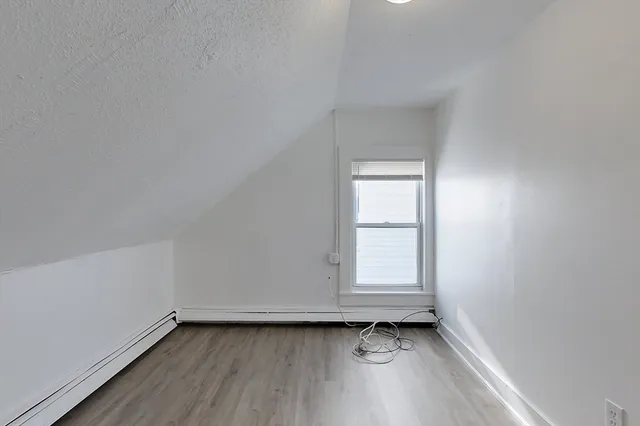 an empty room with wooden floor and window