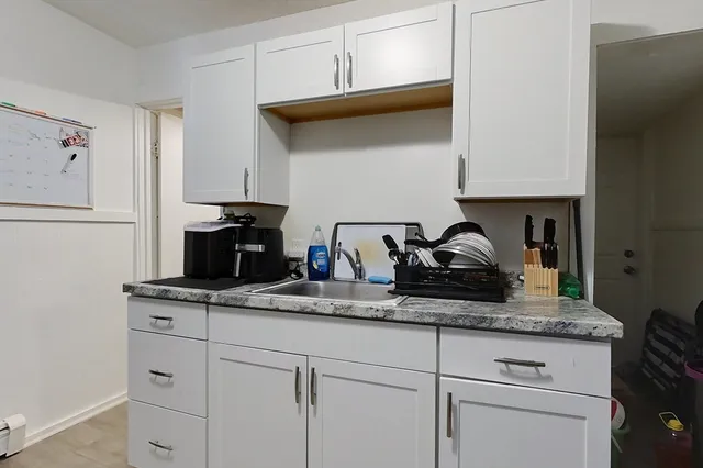 a kitchen with white cabinets and appliances