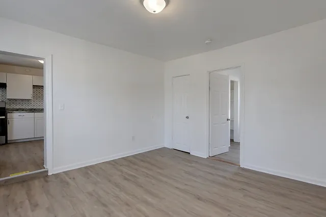 a view of empty room with wooden floor